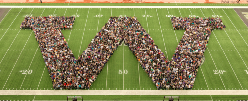 Photo of UW students in the shape of a "W" on the Husky Stadium field.